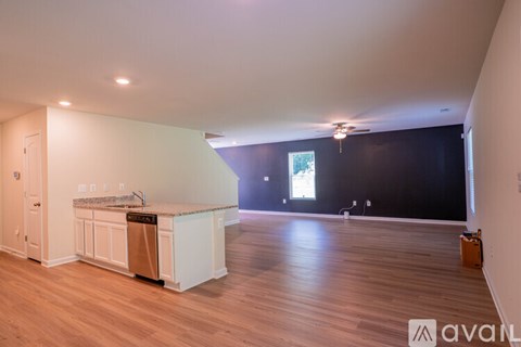 A kitchen with white cabinets and a wooden floor.