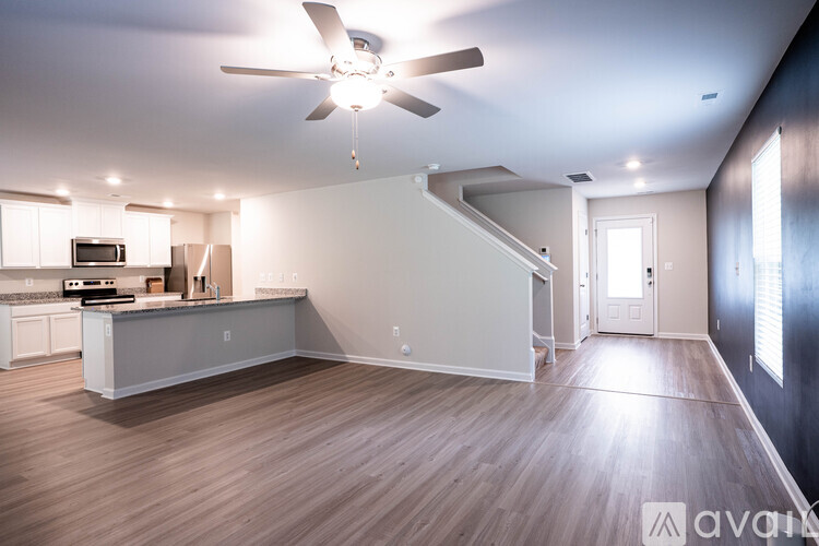 A spacious room with a ceiling fan and lighting fixture.