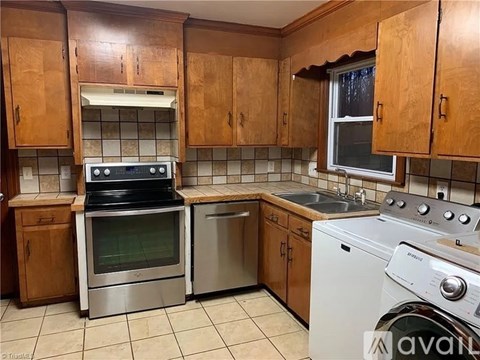 A kitchen with wooden cabinets and a white washing machine.