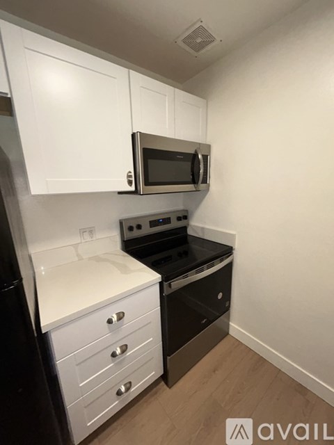 A kitchen with a black oven and white cabinets.