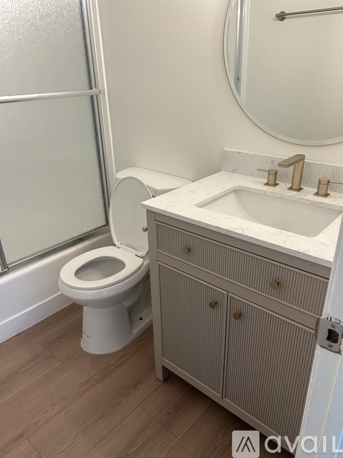 A bathroom with a toilet, sink, and a cabinet.
