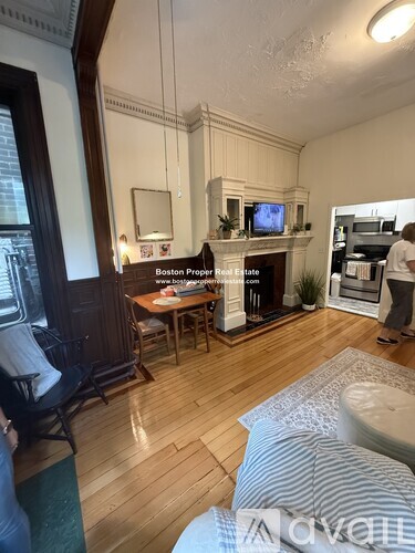 A living room with a fireplace and a tv on the mantle.