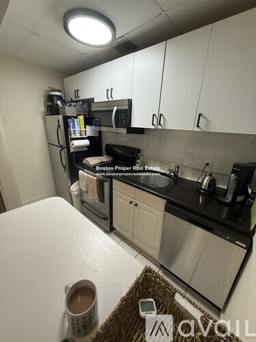A kitchen with a white table and a refrigerator with a magnet on it.