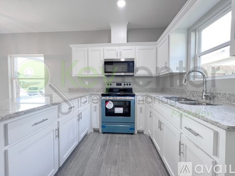 A kitchen with white cabinets and a blue oven.
