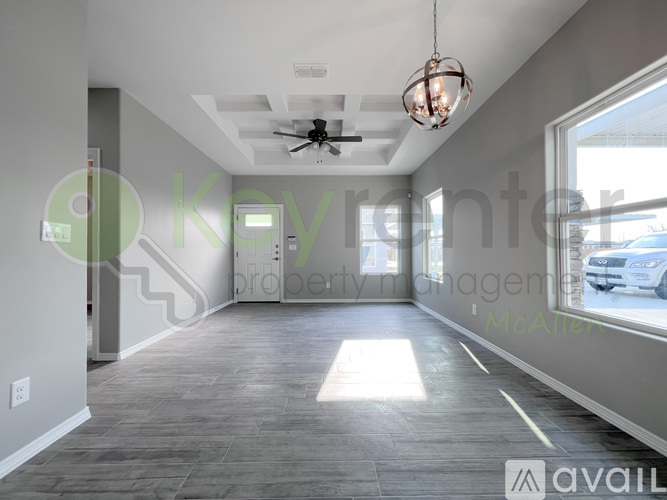 A spacious room with a ceiling fan and a light hanging from the ceiling.