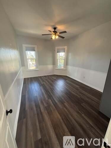 A room with wooden floors and a ceiling fan.
