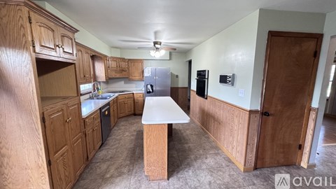 A kitchen with wooden cabinets and a white island.
