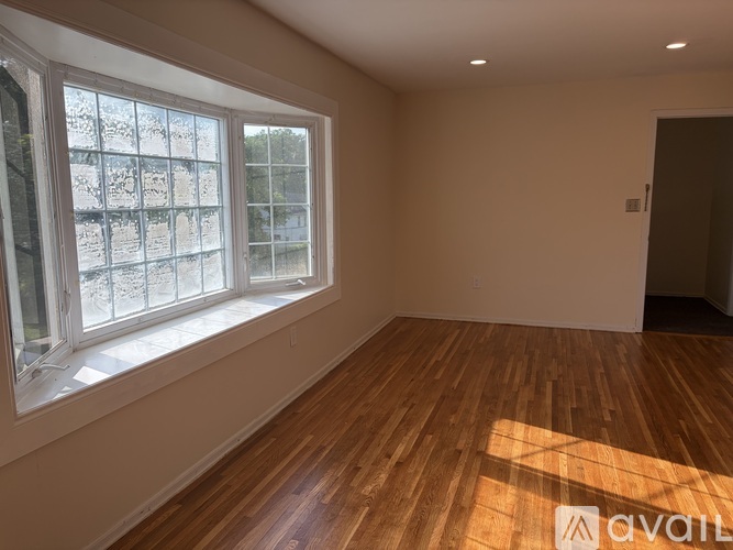 A room with wooden floors and a large window.