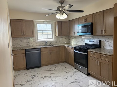 A kitchen with a black dishwasher and stove top oven.