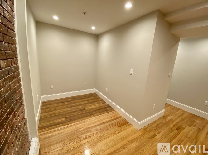 A room with wooden flooring and white walls.
