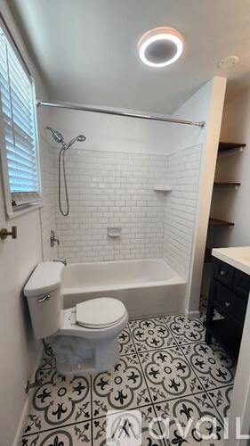 A white bathroom with a black and white floor.