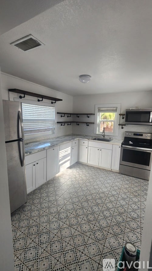 A kitchen with a patterned floor and white cabinets.