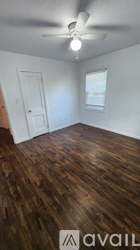 A room with wooden floors and a ceiling fan.