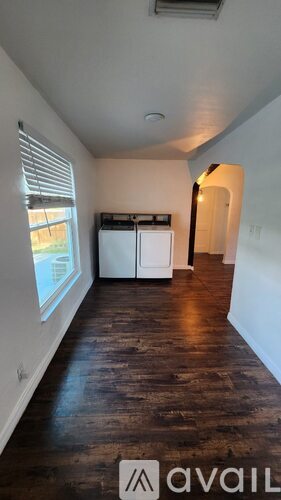 A room with wooden floors and a window with blinds.