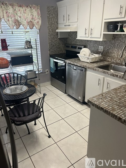 A kitchen with a black chair and a black table.