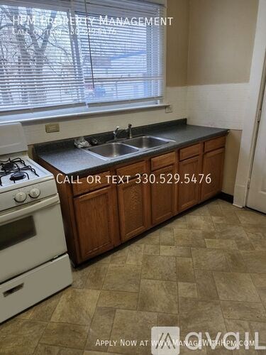 A kitchen with a stove, sink, and cabinets is for rent.