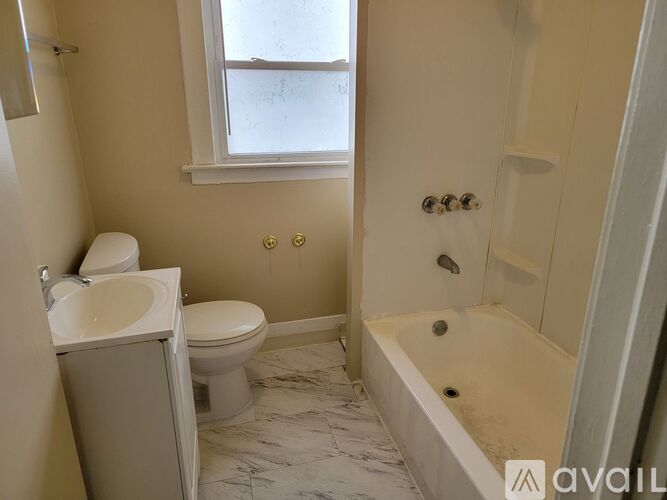 A bathroom with a toilet, sink, and bathtub.