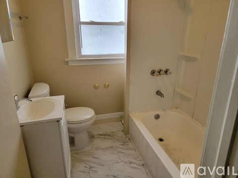 A bathroom with a toilet, sink, and bathtub.