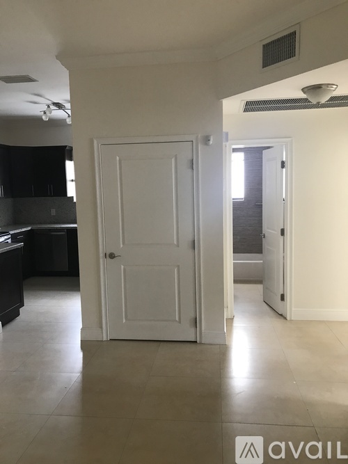 A white door is in a room with a tiled floor.