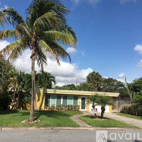 A yellow house with a palm tree in front.