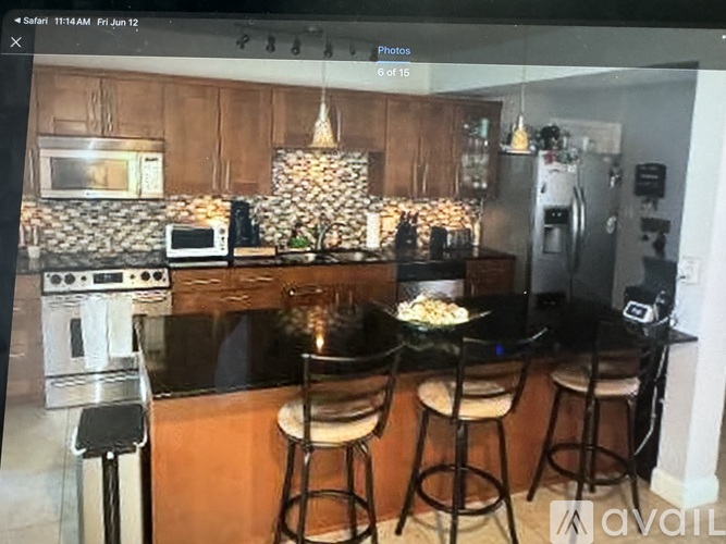 A kitchen with wooden cabinets and a black countertop.