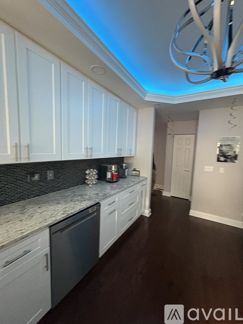 A kitchen with white cabinets and a marble countertop.