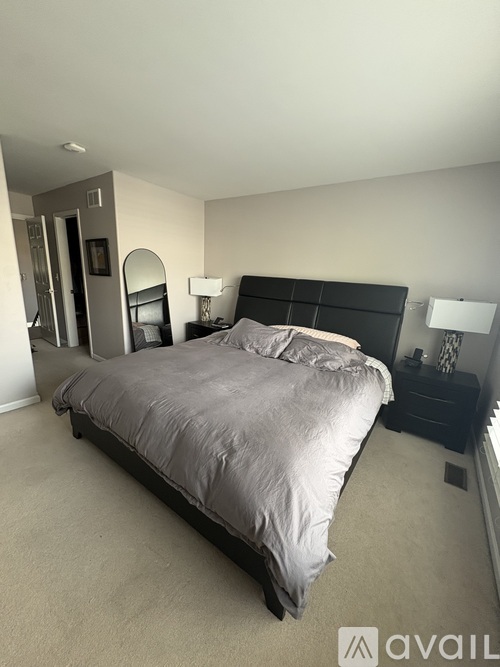 A bedroom with a large bed and a mirror on the wall.