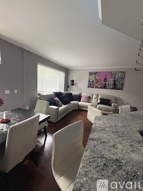 A living room with a grey couch and a grey rug.