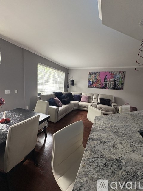A living room with a grey couch and a grey rug.