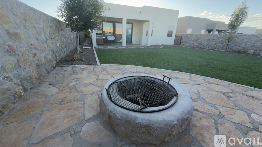 A stone patio with a fire pit in the middle.
