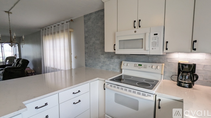 A kitchen with a white countertop and a white oven.
