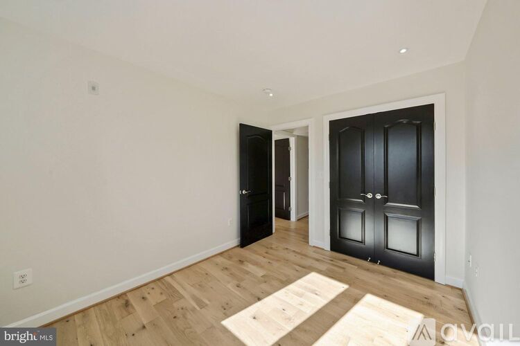 A room with a black door and a wooden floor.