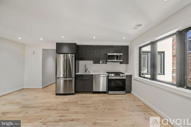 A kitchen with a stainless steel refrigerator, oven, and microwave.