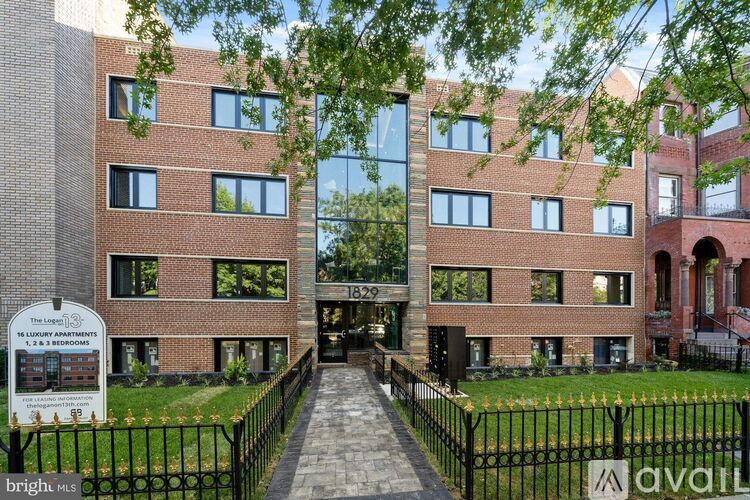 The image shows a brick building with a sign that reads "The LUXURY APARTMENTS".