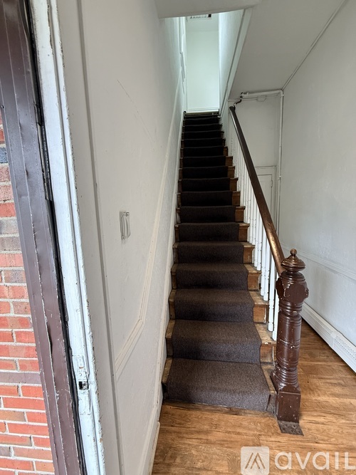 A staircase with a carpeted runner and wooden balusters.