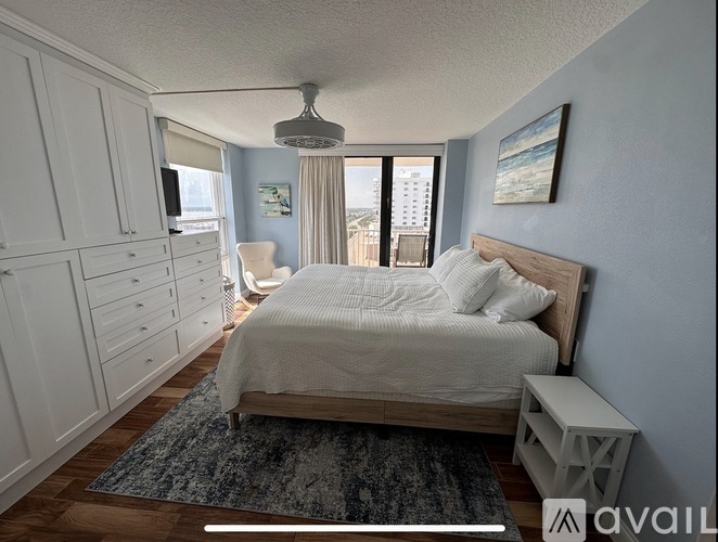 A bedroom with a large bed and a television on the wall.