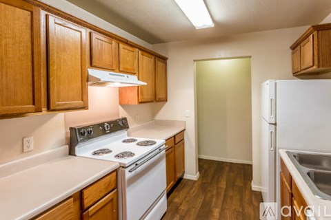 A kitchen with wooden cabinets and a white stove top oven.