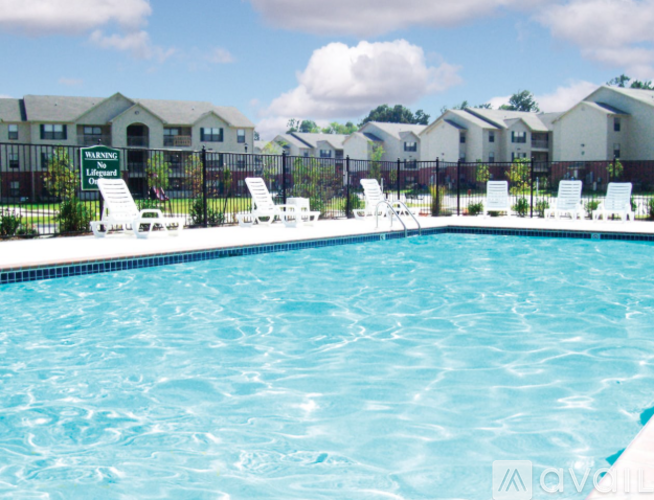 A pool with chairs and a sign that says "Senior Living" in front of a building.