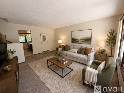 A living room with a couch, coffee table, and a painting on the wall.