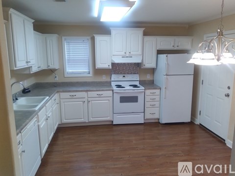 A kitchen with white cabinets and a white refrigerator.
