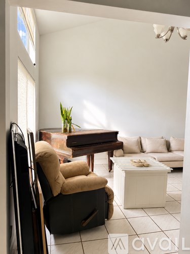 A living room with a brown chair and a white sofa.