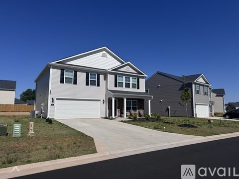 A modern house with a grey garage door is available for purchase.