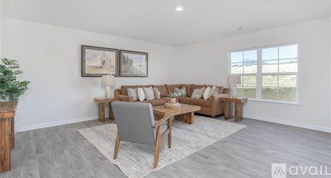 A living room with a grey couch and a wooden coffee table.