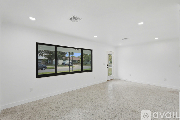 A spacious room with a large window and a door.