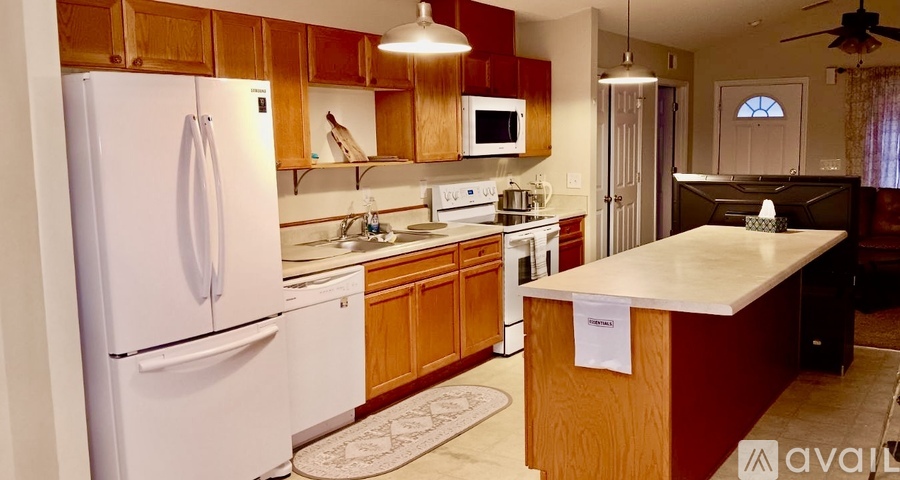 A kitchen with a white refrigerator and wooden cabinets.