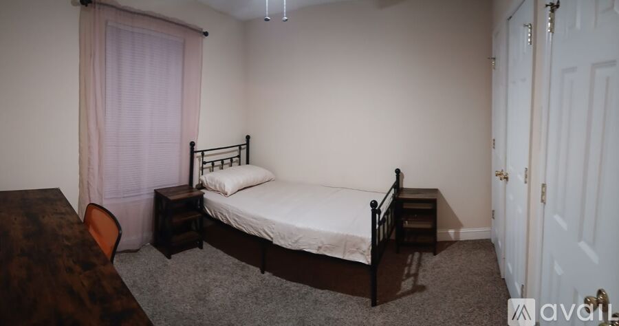 A bedroom with a bed, nightstand, and chair.