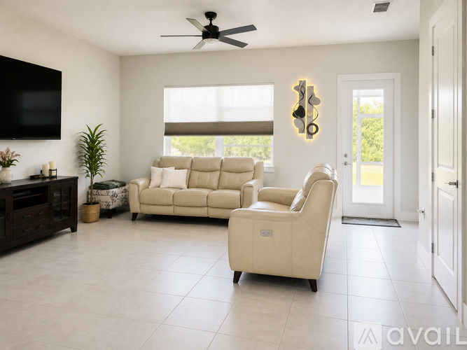 A living room with a white ceiling fan and a white chair.