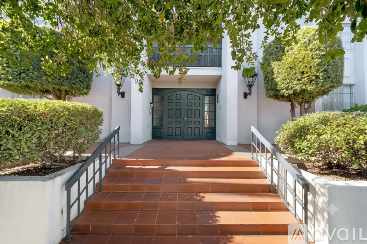 A white building with a black door and steps leading up to it.