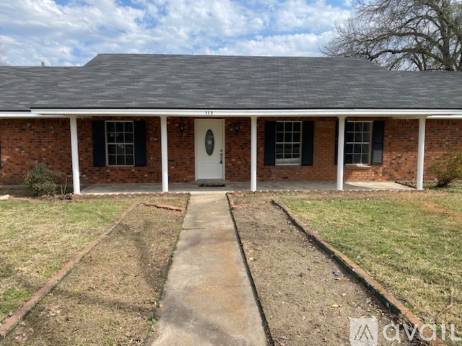 A brick house with a white door and windows.