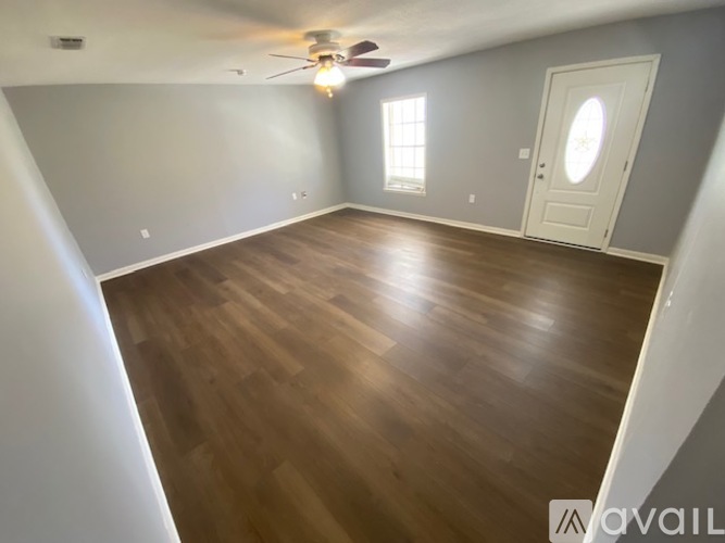 A room with wooden flooring and a ceiling fan.